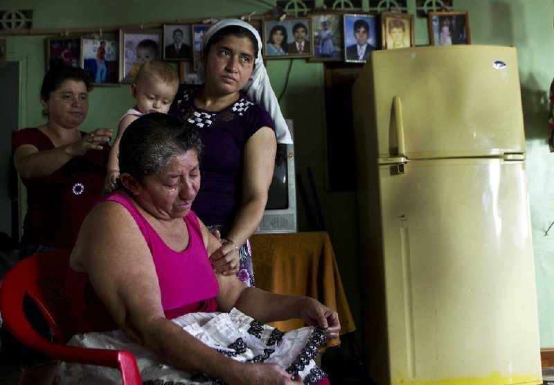 Maria Julia Alvarenga, the mother of Jose Salvador Alvarenga, is comforted by relatives during an interview inside her home Tuesday in the village of Garita Palmera, El Salvador. 