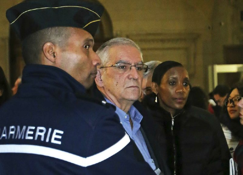 Alain Gauthier (center), a French schoolteacher and creator of the Collective of Civil Plaintiffs for Rwanda, and his wife, Dafroza, arrive at Paris law court Tuesday for the trial of Pascal Simbikangwa. 