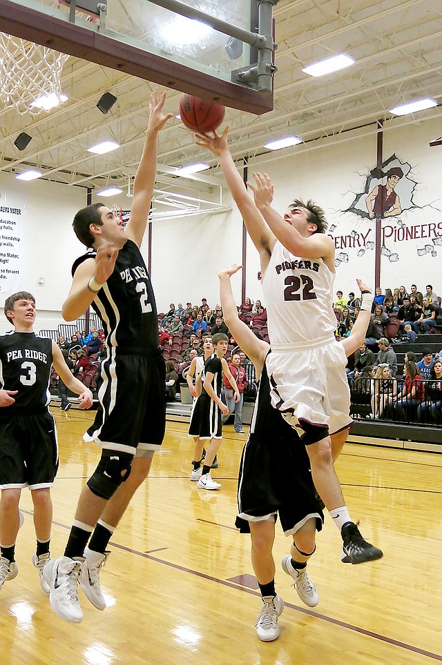 Photo by Randy Moll Gentry junior, Brent Barker, attempts a shot over Pea Ridge junior, Tristan Trundle, in play between the two teams at Gentry on Jan. 28.