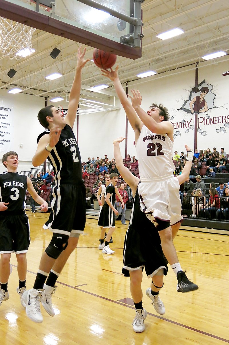 Photo by Randy Moll Gentry junior, Brent Barker, attempts a shot over Pea Ridge junior, Tristan Trundle, in play between the two teams at Gentry on Jan. 28.