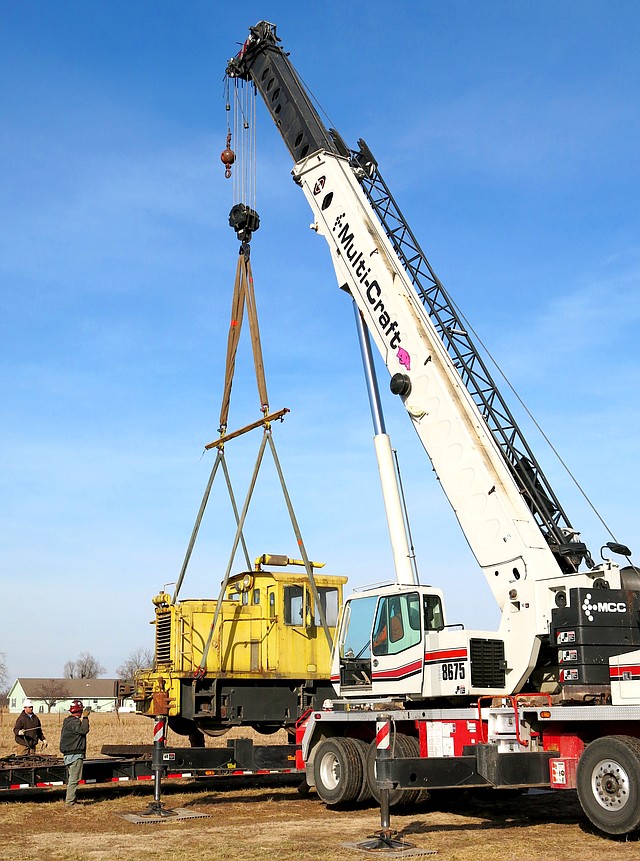 Photo by Randy Moll A 1943, 25-ton, switch locomotive is lifted by crane from a truck trailer at the Tired Iron of the Ozarks showgrounds on Thursday. The club plans to restore the old engine to its original condition as a showpiece.