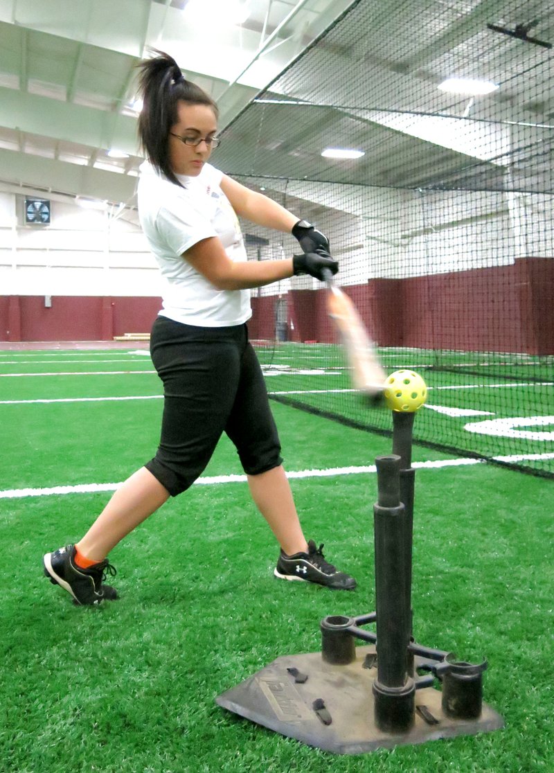 Photo by Randy Moll Courtney Brown practices her swing during softball practice inside the new multi-purpose athletic facility on the Gentry High School campus on Jan. 29.