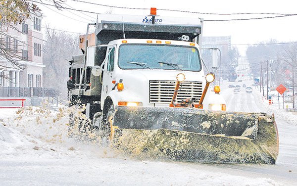 An Arkansas Highway and Transportation Department snow plow clears School Street Tuesday morning in south Fayetteville. Northwest Arkansas received a wintry mix of rain, sleet and snow throughout the day.