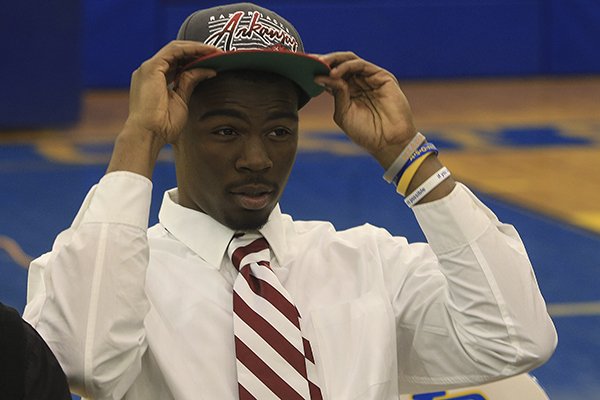 North Little Rock's Juan Day puts on a Razorback hat Wednesday morning after signing to play football for the University of Arkansas. North Little Rock's Juan Day puts on a Razorback hat Wednesday morning after signing to play football for the University of Arkansas.