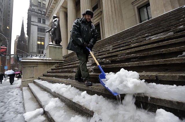 U.S. Parks Service worker Danny Merced clears snow from the steps of Federal Hall in New York on Wednesday.