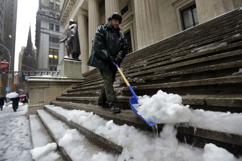 U.S. Parks Service worker Danny Merced clears snow from the steps of Federal Hall in New York on Wednesday.