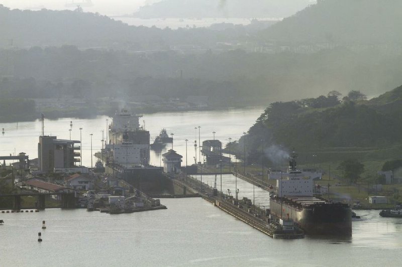 A cargo ship exits a lock on the Panama Canal in Panama City on Tuesday. A construction group working on the expansion of the canal said it slowed work Wednesday in response to concerns about not being paid for cost overruns. 