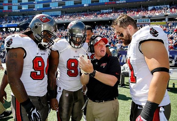 Tampa Bay linebackers coach Robb Smith goes over a play with defensive end Adrian Clayborn, defensive end Da'Quan Bowers and defensive end Trevor Scott during a 2013 game.