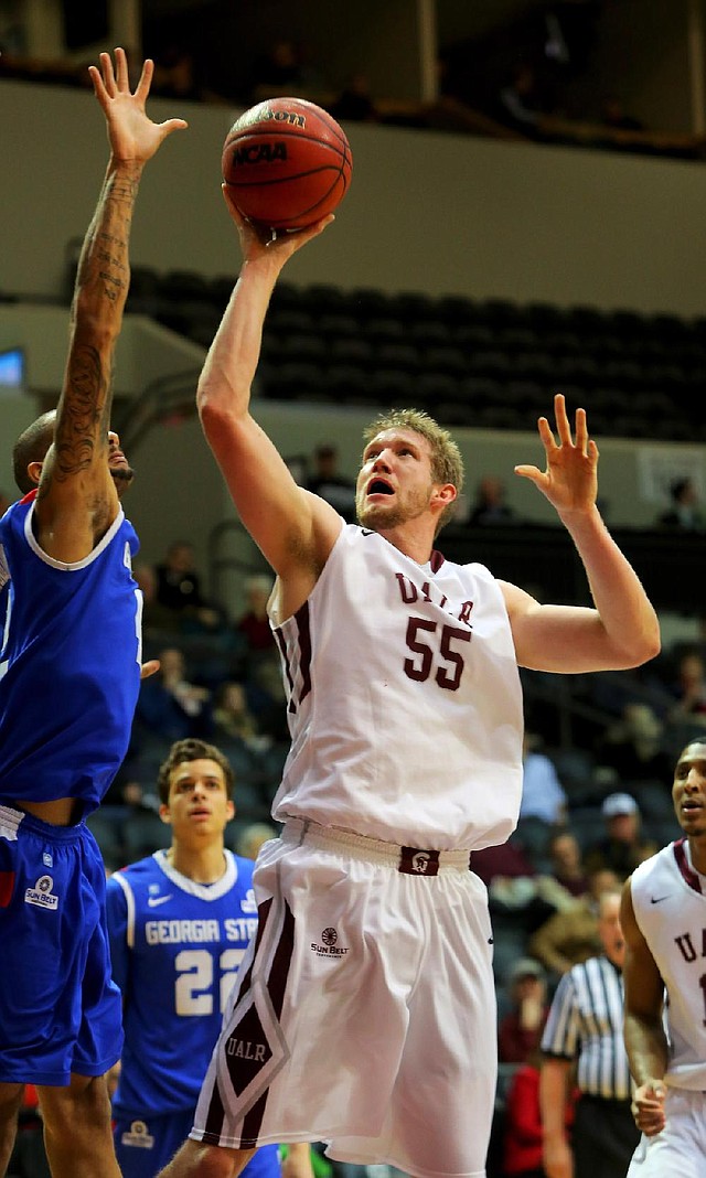 UALR’s Gus Leeper (55) gets his shot blocked by Georgia State’s Curtis Washington (left) during the first half of the Trojans’ 68-57 loss to the Panthers on Thursday at the Jack Stephens Center in Little Rock. 