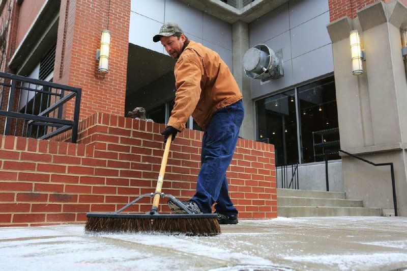 Arkansas Democrat-Gazette/RICK MCFARLAND --02/06/14--  Mark Morrissey sweeps a dusting of snow off of the sidewalk along East 3rd Street in Little Rock Thursday.