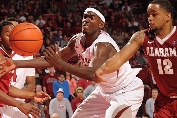 Arkansas freshman Bobby Portis, center, collects a rebound in front of Alabama senior Trevor Releford (12) during the second half of play Wednesday, Feb. 5, 2014, in Bud Walton Arena in Fayetteville.