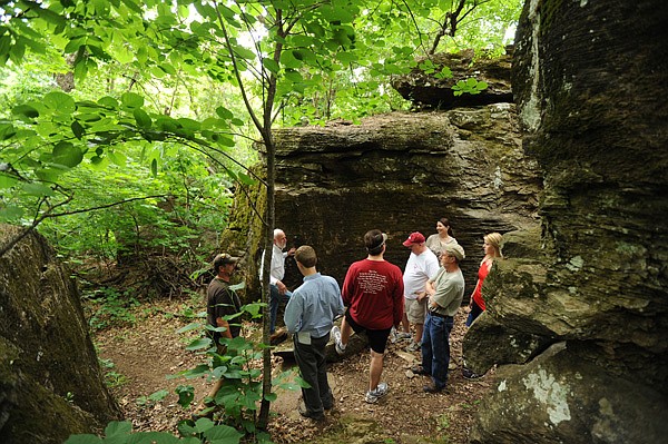 Phil Penny, director of the Ozark Offroad Cyclists group, left, and Frank Sharp describe a historic trail through 'Rock City' on Kessler Mountain Friday, April 27, 2012, to a group of city of Fayetteville officials and Parks and Recreation Advisory Board members during a tour of the area that property owners and local conservation leaders are working to preserve.