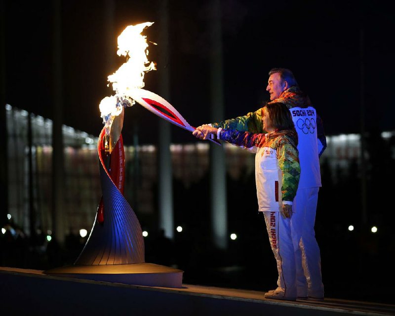 Irina Rodnina and Vladislav Tretiak light the Olympic cauldron during the opening ceremony of the 2014 Winter Olympics in Sochi, Russia, Friday, Feb. 7, 2014. (AP Photo/Matt Slocum, Pool)