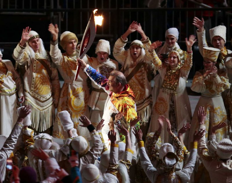 Vladislav Tretiak carries the torch during the opening ceremony of the 2014 Winter Olympics in Sochi, Russia, Friday, Feb. 7, 2014. (AP Photo/Ivan Sekretarev)