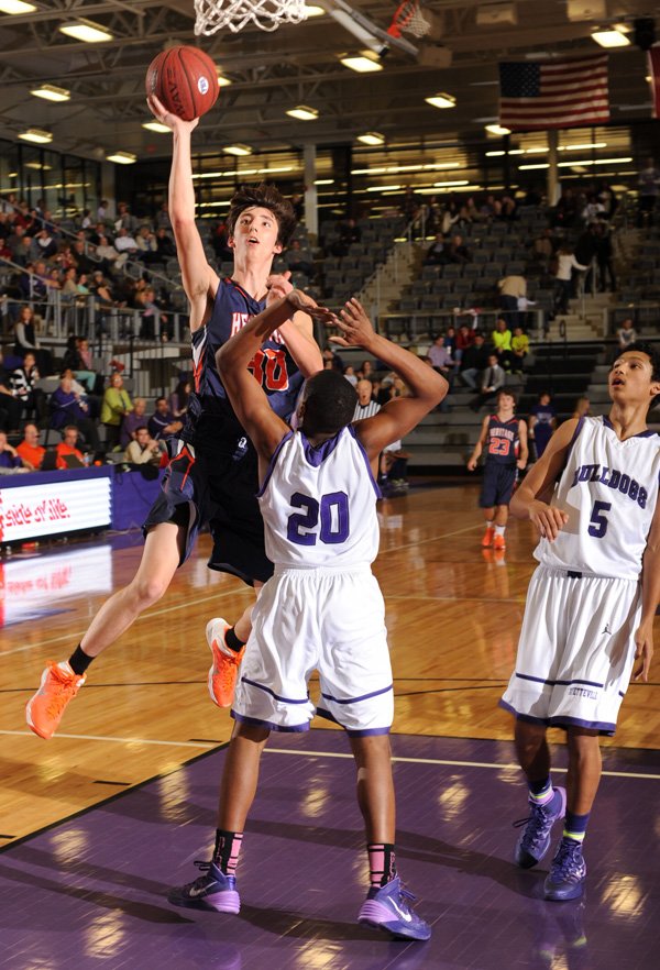 Rogers Heritage senior Austin Prince, left, scores as Fayetteville senior JaQuay Prude (20) defends during the second half of play Friday, Feb. 7, 2014, at Fayetteville high.