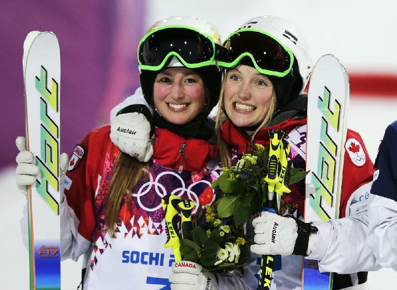 Canadian skier Justine Dufour-Lapointe (right) celebrates her gold medal in the women’s moguls final with her sister and silver medalist Chloe Dufour-Lapointe at the Rosa Khutor Extreme Park, on Saturday at the Winter Olympics in Krasnaya Polyana, Russia. 