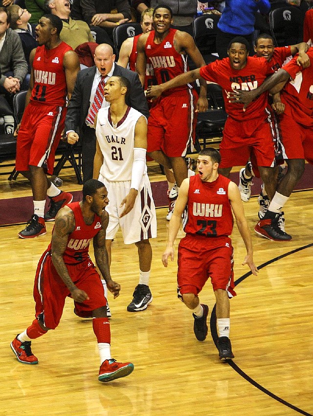 UALR’s Mareik Isom (21) walks off the court after Western Kentucky’s Trency Jackson (left) made a three-pointer with no time left to defeat the Trojans 79-78 at the Jack Stephens Center in Little Rock. Jackson finished with 20 points to lead the Hilltoppers, who improved to 16-7 overall and 8-2 in the Sun Belt Conference. UALR dropped to 12-12 overall and 7-5 in the Sun Belt. More photos at arkansasonline.com/galleries. 