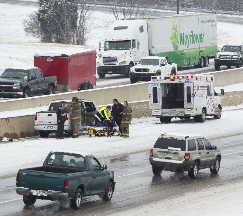 Emergency personnel tend to a pickup driver who lost control of his vehicle Saturday and hit the side wall on Interstate 40 eastbound in North Little Rock.