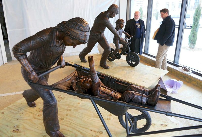 2/6/14
Arkansas Democrat-Gazette/STEPHEN B. THORNTON
County Judge Buddy Villines and landscape architect Tanner Weeks look over Kevin Kresse's  finished sculpture entitled "Family" as it sits on display in a window at @nd Street and Broadway in Little Rock.  The county is requesting bids to have the piece installed in Two Rivers Park.