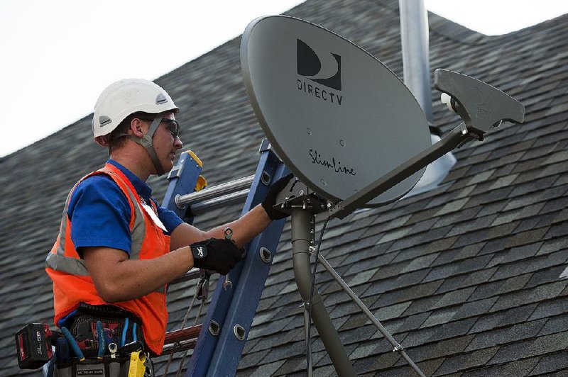 Jordan Schlupe, a DirecTV employee, performs a satellite installation at a customer's home in Bixby, Oklahoma, U.S., on Monday, June 27, 2011. DirecTV, the El Segundo, California-based company, is the largest U.S. satellite-television company. Photographer: Paul Taggart/Bloomberg *** Local Caption *** Jordan Schlupe