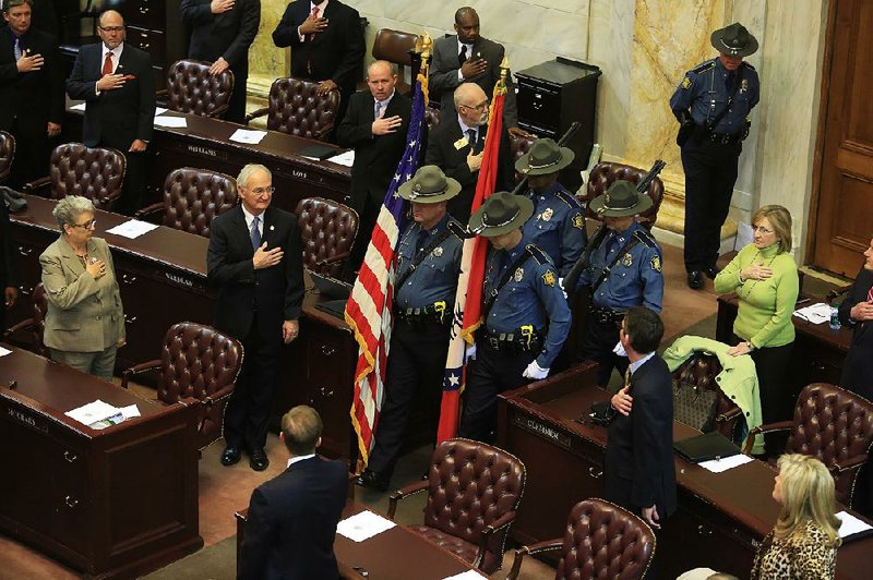 Arkansas Democrat-Gazette/RICK MCFARLAND --02/10/14--  Members of the Arkansas House of Representatives stand and cover their hearts as the Colors are brought in by the Arkansas State Police Honor Guard at the start of the fiscal session at the state Capitol in Little Rock Monday. 