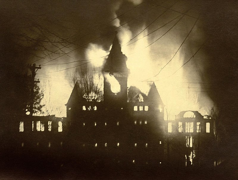 SUBMITTED
This 1913 photograph, showing the fire engulfing Old Main at what was then Henderson-Brown College in Arkadelphia, is part of a display in the Huie Library at Henderson State University commemorating the 100th anniversary of the blaze. While it could have forced the college to close, the blaze is credited with being the “spark” that ignited what the students call the Reddie Spirit of HSU.