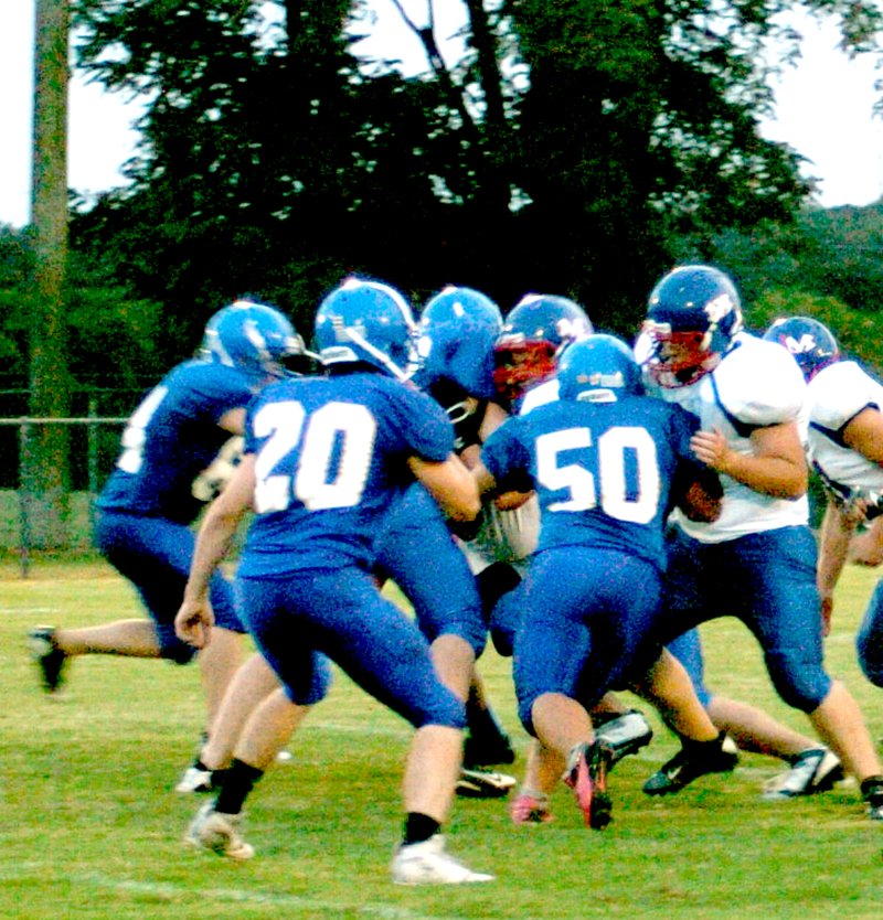 Photo by Mike Eckels Matt Lee (#50) loves to be in the thick of things as he and fellow Bulldogs effectively shut down a run during the Decatur/Mountainburg game of Sept. 20. Lee also participates on the senior basketball team. Although he makes an outstanding player in any sport, his first love is football.