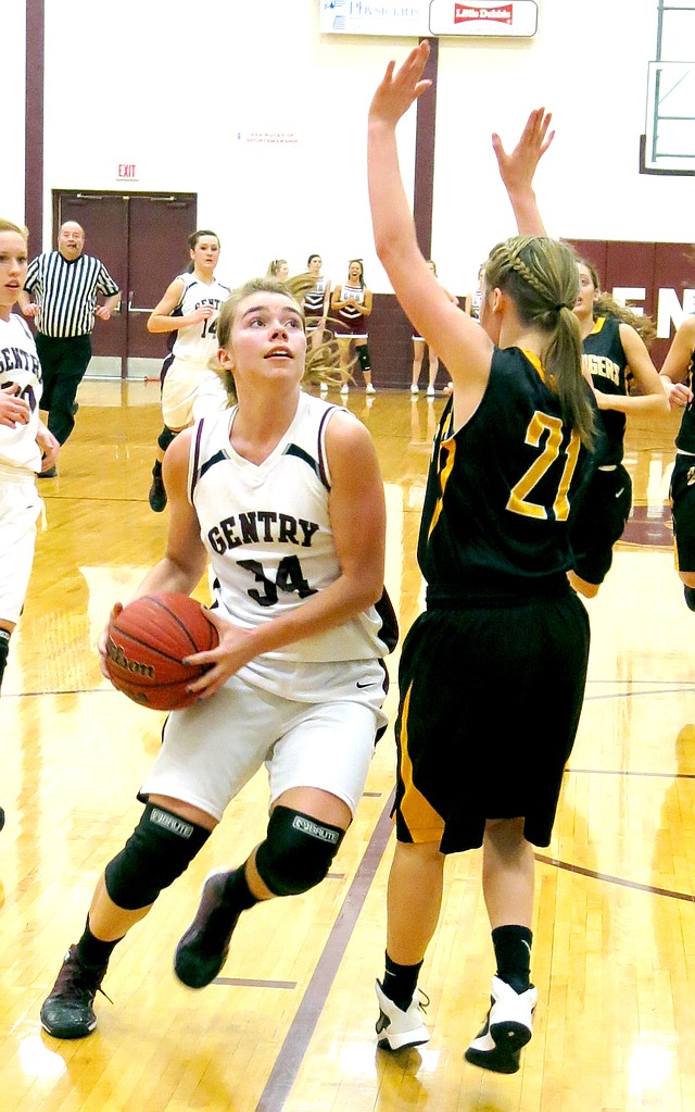 Photo by Randy Moll Haley Borgeteien-James, Gentry sophomore, drives past Taylor Hartin of Prairie Grove to take a quick shot under the basket during play on Friday in Gentry.