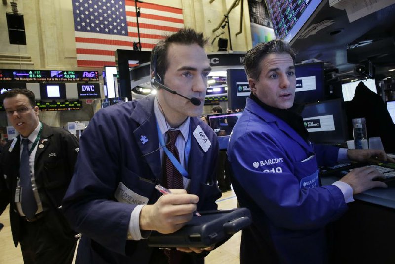 Gregory Rowe (center) places orders for stock with Anthony Rinaldi (right) on Wednesday on the floor of the New York Stock Exchange. 