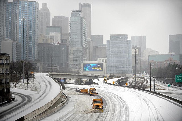 Snowplows clear Interstate 75/85 in Atlanta on Wednesday as most people stayed off the roadways. 