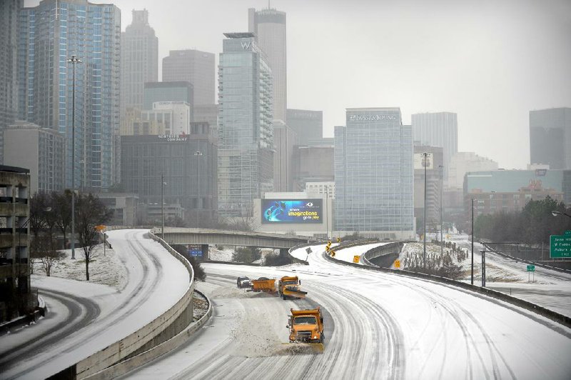 Snowplows clear Interstate 75/85 in Atlanta on Wednesday as most people stayed off the roadways. 