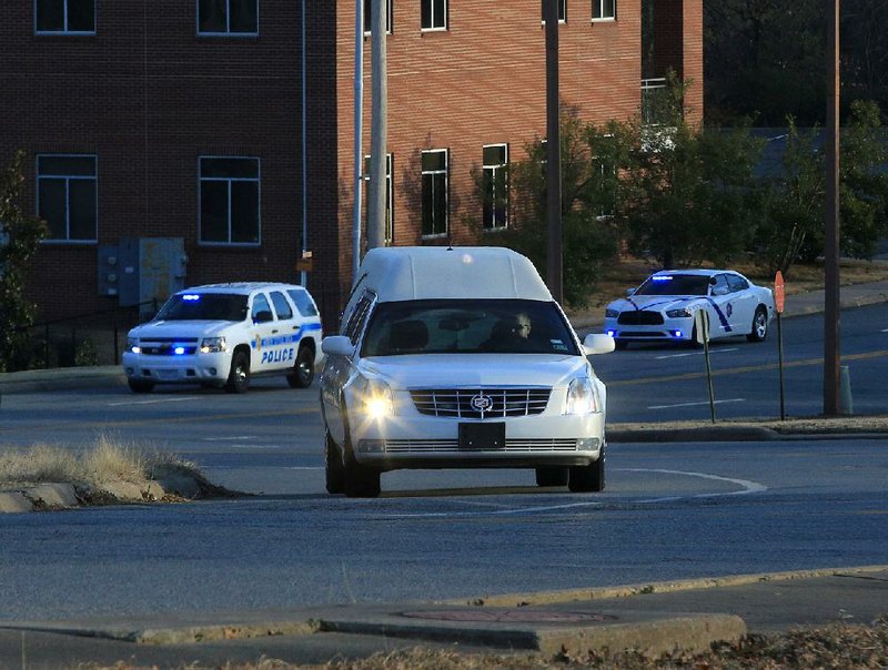 A hearse carrying the remains of pilot Jake Harrell arrives Wednesday evening at the state Crime Laboratory in Little Rock. 