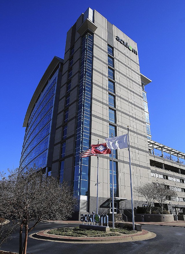 Flags fly Thursday outside Acxiom Corp.’s building in downtown Little Rock. Company leaders say they are watching for changes in government policy on data collection after President Barack Obama announced plans to reform the nation’s spy programs. 