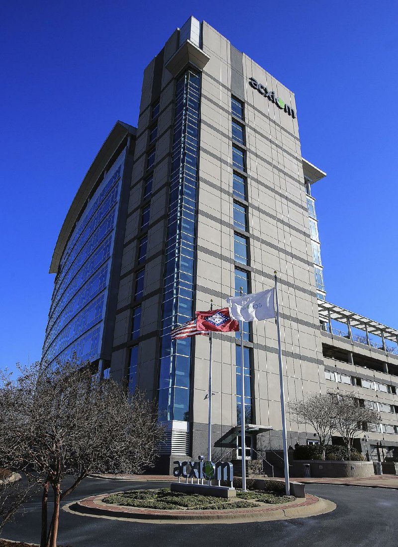 Flags fly Thursday outside Acxiom Corp.’s building in downtown Little Rock. Company leaders say they are watching for changes in government policy on data collection after President Barack Obama announced plans to reform the nation’s spy programs. 