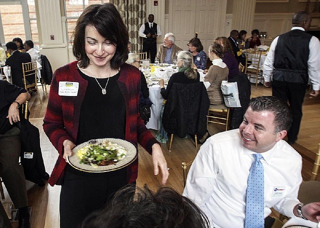 Cynthia Edwards, Arkansas’ deputy agriculture secretary, helps serve a lunch of Arkansas-grown food Monday after a gathering for farmers and retailers at the Governor’s Mansion. 