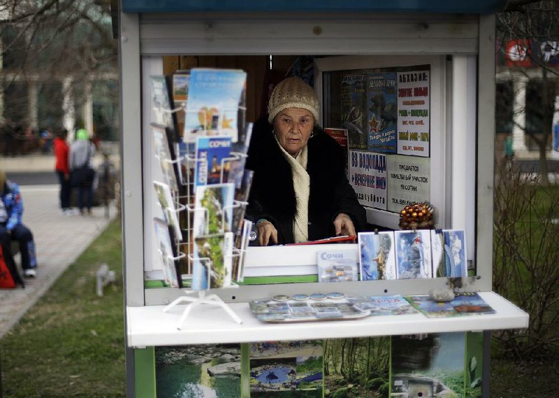 Sochi native Dina Kobolenko waits for tourists in her kiosk that sells maps, books and postcards outside the central train station in Sochi, Russia. Local businesses and residents have a lot to gain if these Olympics fulfill Putin’s pledge to turn Sochi into a year-round international resort. 