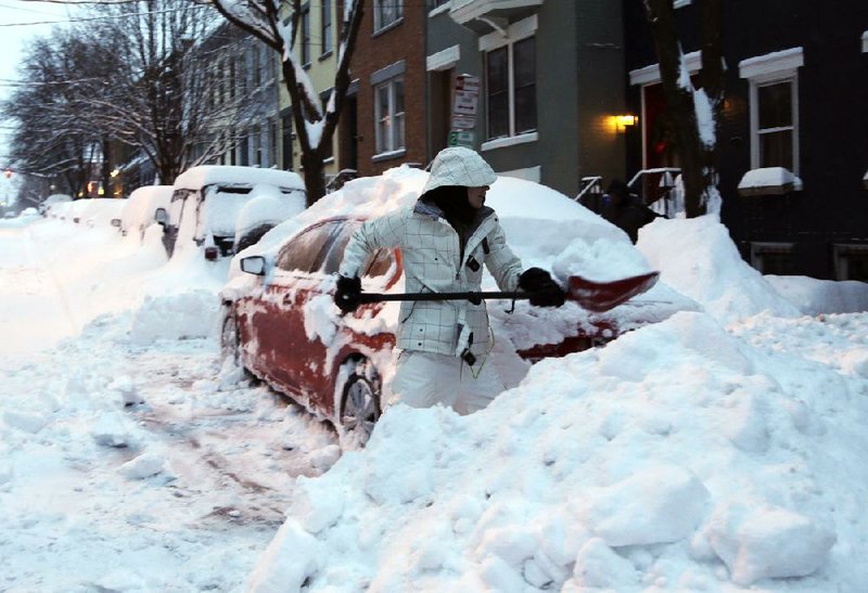 Liz Hall digs her car out Friday in Albany, N.Y. Snowfall of 12 to 27 inches closed schools across the state, but in New York City classes were held to the chagrin of many parents, including TV weatherman Al Roker. 