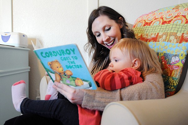 Julie Petree, manager of marketing and communications for United Way of Northwest Arkansas, reads Corduroy Goes to The Doctor by Don Freeman to her daughter, Wren, 22 months, Thursday, Feb. 13, 2014, at their home in Rogers. Wren receives a book a month through the Dolly Parton Imagination Library, a programs sponsored by the United Way of Northwest Arkansas.