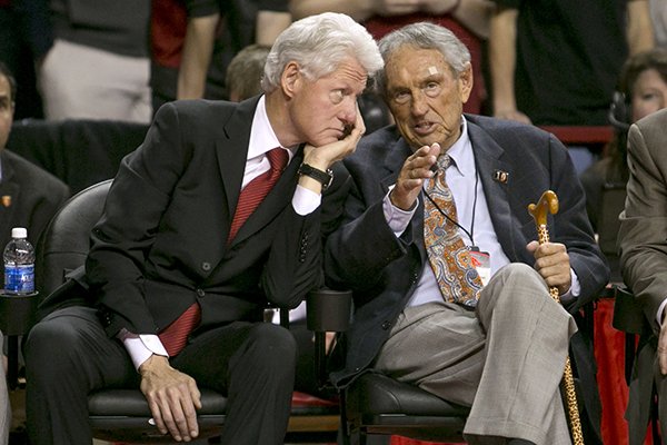 Former president Bill Clinton and former Arkansas coach Eddie Sutton, right, talk during the second half of an NCAA college basketball game between Arkansas and LSU on Saturday, Feb. 15, 2014, in Fayetteville, Ark. (AP Photo/Gareth Patterson)