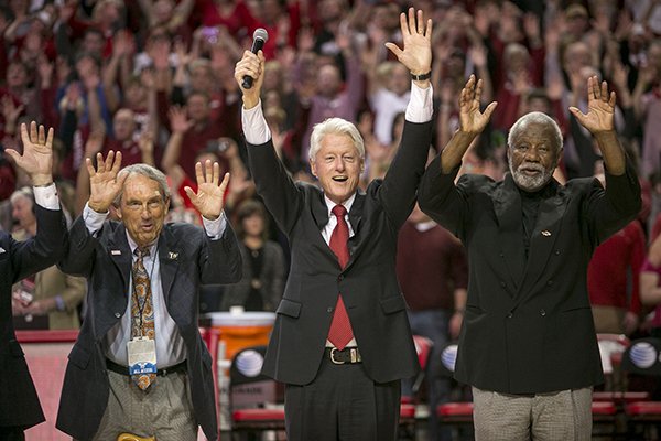 Eddie Sutton, left, former President Bill Clinton, center, and Nolan Richardson, right, call the "Hogs" during halftime of an NCAA college basketball game between Arkansas and LSU on Saturday, Feb. 15, 2014, in Fayetteville, Ark. (AP Photo/Gareth Patterson)
