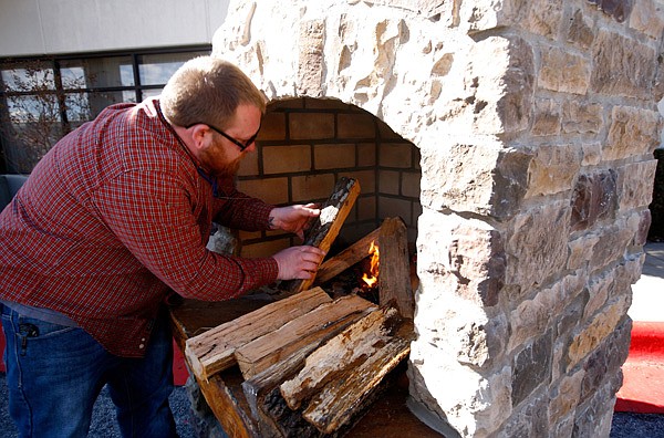 Travis Bounds with Builders Stone & Supply builds a fire in an outdoor fireplace outside the Northwest Arkansas Convention Center in Springdale on Friday, Feb. 14, 2014, during the Northwest Arkansas Home Builders Association Home Show. The show continues through Sunday at the center.