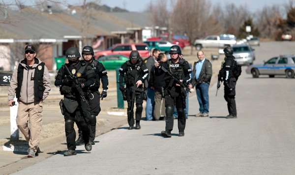 Springdale Police walk back down Twin County Street on Friday, Feb. 14, 2014, following a standoff at a residence on the street. Jonathan Fuller (***CONFIRM SPELLING WITH ERIN'S STORY***) was placed in custody following the incident.