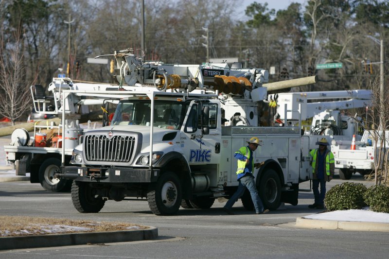 Power crews assemble at a grocery store that was close due to the power outages caused by an ice storm this week Friday in Evans, Ga. Nearly a million homes and businesses in Georgia lost power after a storm blanketed the region with snow and ice, but most had power restored by Friday morning. Georgia utility companies said a total of 989,400 customers lost power in the wake of this week's storm. About 175,000 customers were still without service Friday morning. 