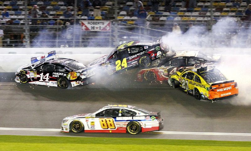 Tony Stewart (14), Jeff Gordon (24), Kurt Busch, second from right, and Matt Kenseth (20) wreck on the front stretch as Dale Earnhardt Jr. (88) goes low to avoid the crash during the NASCAR Sprint Unlimited auto race at Daytona International Speedway in Daytona Beach, Fla., Saturday, Feb. 15, 2014. (AP Photo/Terry Renna)
