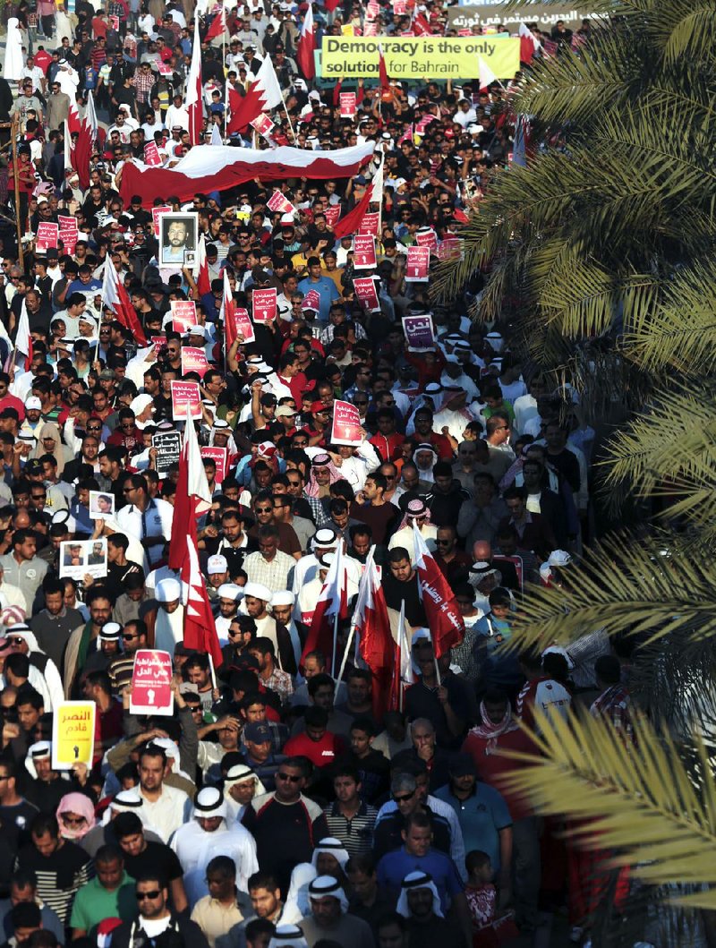 Tens of thousands of pro-democracy protesters march Saturday near Barbar, Bahrain, waving flags, signs and pictures of prisoners and people killed in three years of unrest. 