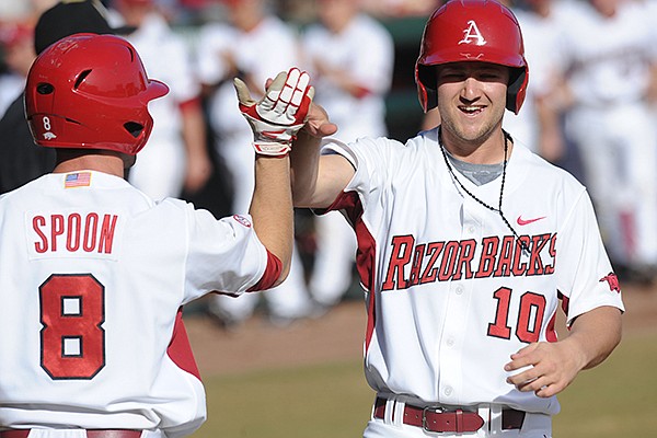 Arkansas left fielder Joe Serrano (10) is congratulated at the plate by right fielder Tyler Spoon as he scores a run after hitting an RBI double to break a 3-3 tie during the seventh inning Sunday, Feb. 16, 2014, against Appalachian State at Baum Stadium in Fayetteville.