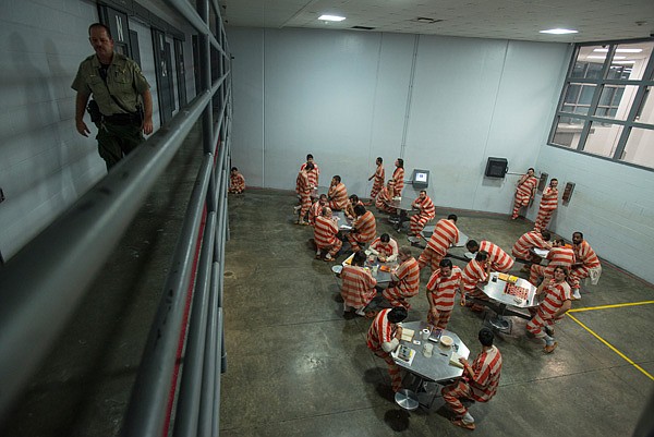 Inmates spend time in dayroom Friday, Feb. 14, 2014 at the Washington County Jail in Fayetteville. The jail is overcrowded in certain pods which has made it more dangerous. Overcrowding in pods forces some inmates to sleep on extra mats on the floor.
