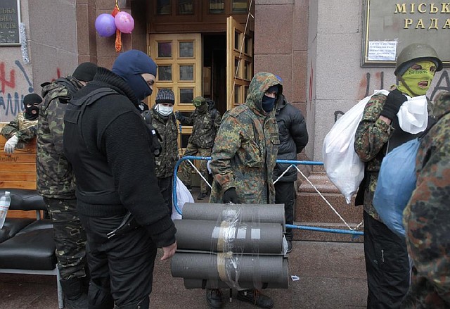 Opposition supporters leave Kiev City Hall in Kiev, Ukraine, Sunday, Feb. 16, 2014. Anti-government demonstrators in Ukraine's capital ended their nearly three-month occupation of Kiev City Hall on Sunday as promised in exchange for the release of all jailed protesters. But tensions remained high as hundreds stayed outside the building, vowing to retake it if the government fails to drop all criminal charges against the protesters. (AP Photo/Sergei Chuzavkov)