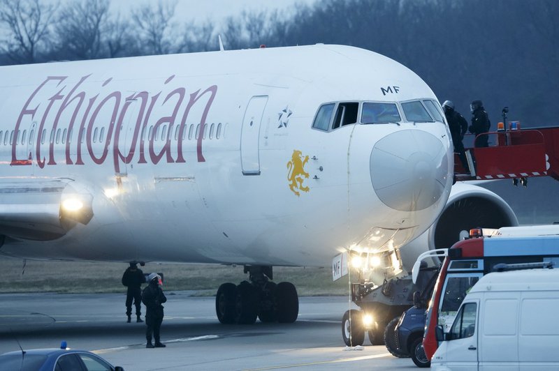 Police stand around the aircraft after passengers were evacuated from a hijacked Ethiopian Airlines Plane on the airport in Geneva on Monday, Feb. 17, 2014. A hijacked aircraft traveling from Addis Abeda, Ethiopia, to Rome, Italy, has landed at Geneva's international airport early Monday morning. Swiss authorities have arrested the hijacker. 