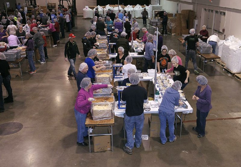 In this Feb. 14, 2014 photo, volunteers pack food for the malnourished during the 2 Million Meals event, in Novi, Mich. More than 8,000 people helped pack 2 million-plus meals, which will be shipped to El Salvador, Haiti and the Philippines. Here, volunteers from NorthRidge Church are shown at one of the packing stations. (AP Photo/Detroit News, Clarence Tabb Jr.)